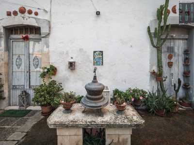 ...preceduto da un tavolino in pietra originale sul quale sono posati una campana di ferro e due vasetti. �� la d�pandance � spiega Lorusso �, realizzata anche questa nel 1896 per trovare una sistemazione al contadino che avrebbe lavorato per la villa e a tutta la sua famiglia: gli Sforza�